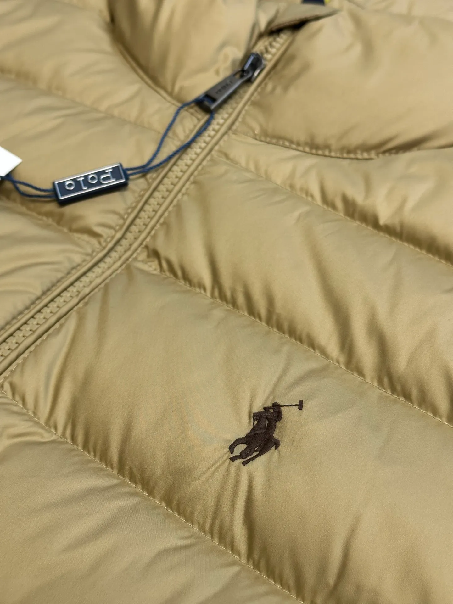 P890 Ralph Lauren lightweight down jacket. The nylon fabric has good windproof and waterproof properties, which can effectively block the intrusion of wind and rain from the outside and keep the inside dry. It is suitable for wearing in humid or rainy environments. The red label on the chest is made with an imported MECLO embroidery machine. The original pattern is scanned first, and then high-quality silk thread is used to make a pattern. The density effect is adjusted by continuous pattern making.  The zipper design is simple and elegant, easy to operate, and the closing design of the cuffs and hem effectively prevents cold wind from invading, improving the warmth and comfort of wearing. It uses 90 white duck down with a weight of 260g to ensure excellent thermal insulation performance. After strict screening and processing, the velvet is not easy to drill, ensuring durability. size: s m l xl